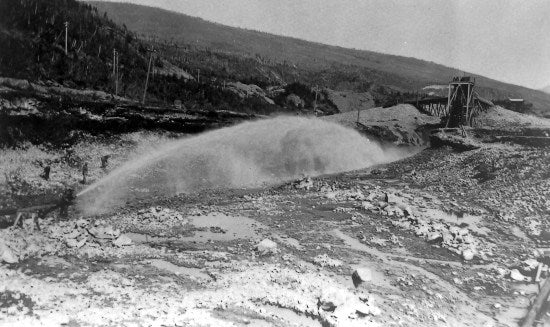 Working a Monitor at Yukon Gold Company Elevator No. 2, at 58 Below Discovery, Bonanza Creek, c1910.