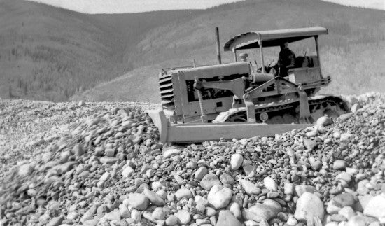Bulldozer Pushing Dredge Tailings, c1937.